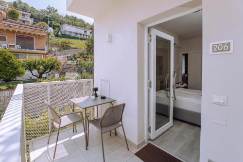 a balcony with a table and chairs and a bathroom at Ah Porticcioli Boutique Apartments in San Felice del Benaco