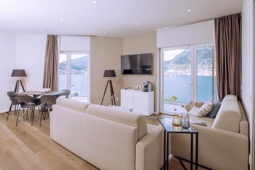 a living room with a large couch and a table at Ah Porticcioli Boutique Apartments in San Felice del Benaco