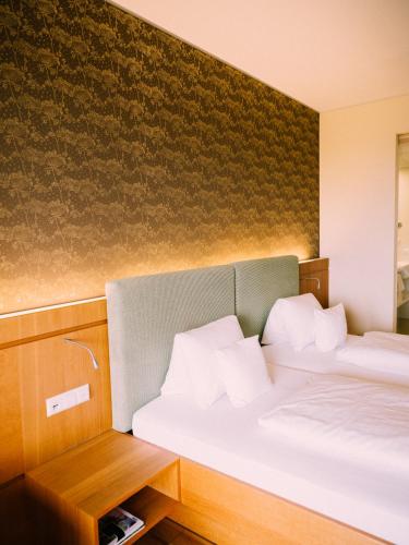 a room with two beds and a wall at Genusshotel Riegersburg in Riegersburg