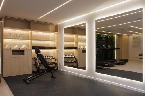 a room with a gym with a mirror and a chair at LUX&EASY Signature Syggrou 234 in Athens