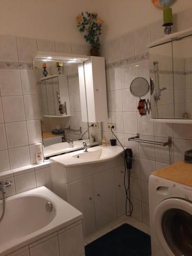 a bathroom with a sink and a tub and a mirror at Charly's Home in Villach