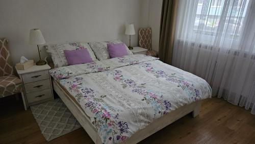 a bedroom with a large bed with purple pillows at Apartmány Rudlová in Banská Bystrica