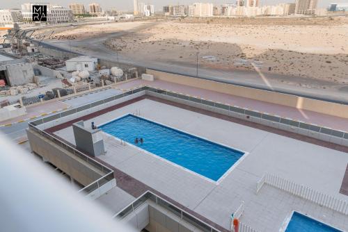 an overhead view of a swimming pool next to a beach at Mira Holiday Homes - Beautiful Studio in Living Legends in Dubai