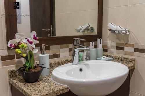 a bathroom with a white sink and a mirror at Mira Holiday Homes - Beautiful Studio in Living Legends in Dubai