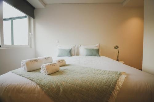 a bedroom with a large bed with two pillows on it at CASA DA RIBEIRA in Viana do Castelo