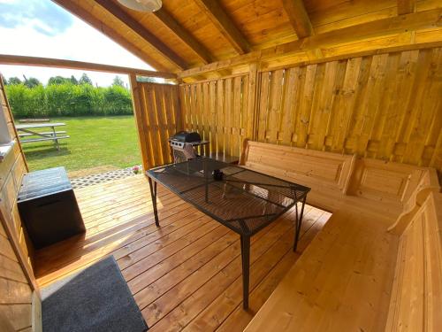 a screened in porch of a wooden cabin with a table at Chata Pod kaplí in Sloup