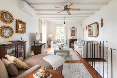 uma sala de estar com um sofá e uma ventoinha de tecto em Quinta Belmonte Funchal no Funchal