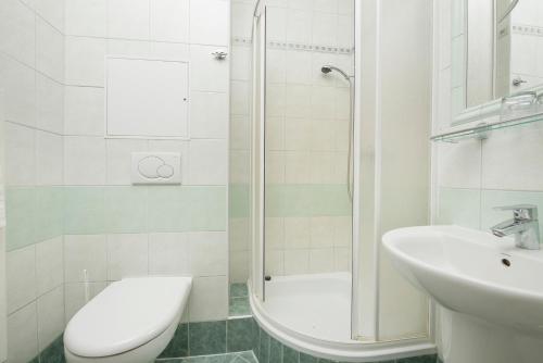 a bathroom with a shower and a toilet and a sink at Hotel SOREA TITRIS in Tatranská Lomnica