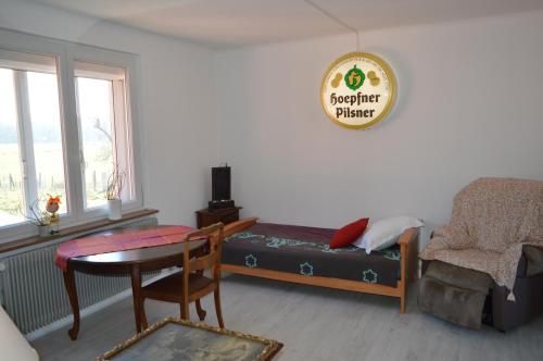 a living room with a bed and a table and a chair at Chez Thérèse et Marguerite in Kindwiller