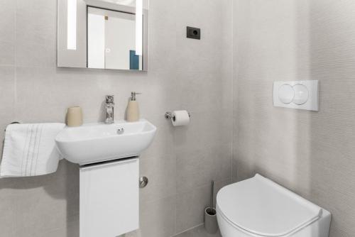 a white bathroom with a sink and a toilet at Villa Edera in Bale