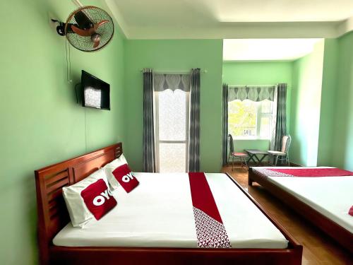 a bedroom with two beds with green walls at SPOT ON 1186 Nha Nghi Huong Mai in Da Nang