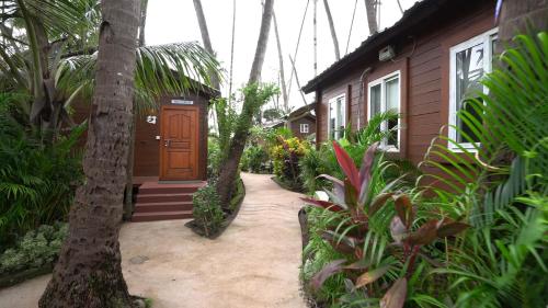 a house with a wooden door and some plants at Tranquil Beach Resort in Harihareshwar