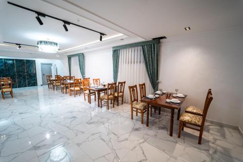 uma sala de jantar com mesas e cadeiras de madeira em Hamilton em Tashkent