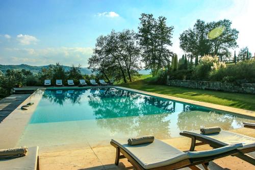 uma piscina com espreguiçadeiras ao lado em Villa Rignana - Chianti Weddings em Greve in Chianti