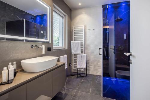 a bathroom with a sink and a glass shower at Quellenhof Luxury Resort Lazise in Lazise