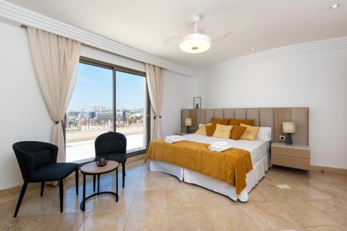 PH BELLAGIO: Luxurious and Romantic duplex penthouse with PRIVATE POOL & sea views في بينالمادينا: غرفة نوم بسرير ونافذة كبيرة