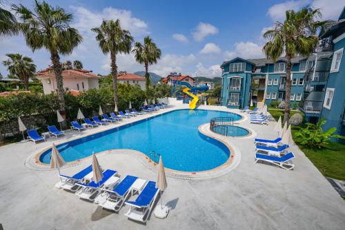 a large swimming pool with lounge chairs and a slide at Oludeniz Region Random Rooms by LookBookHoliday in Oludeniz