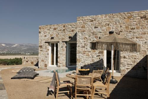a patio with a table and chairs next to a building at Naxian Rhapsody in Stelida