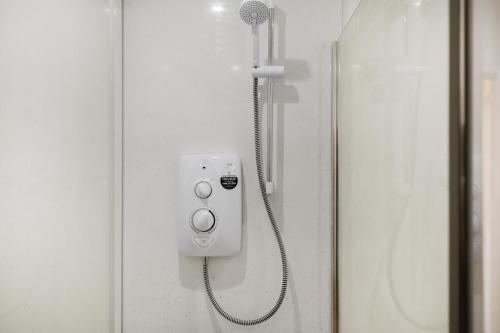 a shower with a shower head on a door at Stylish Good Location Near Tamar Bridge in Saltash