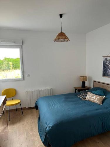 - une chambre avec un lit bleu et une chaise jaune dans l'établissement Chez Mélanie, près de l’abbaye, à Jumièges