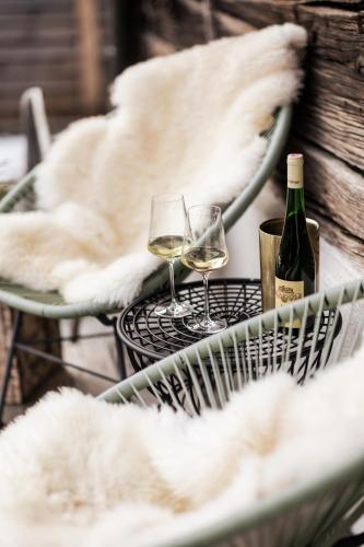 two glasses of white wine sitting on a table at Moxn Chalet Lungau - Authentic Luxury Living in Ramingstein