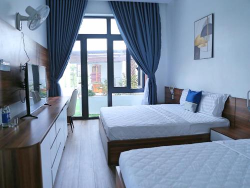 a hotel room with two beds and a window at QV Manor Homestay in Phan Rang