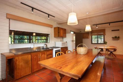 a kitchen with a wooden table and a dining room at Casa no Campo Caminho do Salto in Farroupilha