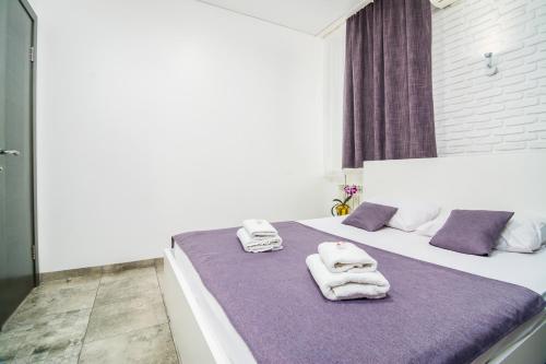 ein Schlafzimmer mit einem weißen Bett und Handtüchern darauf in der Unterkunft Smart Hotel Rooms near metro 24/7 in Kiew