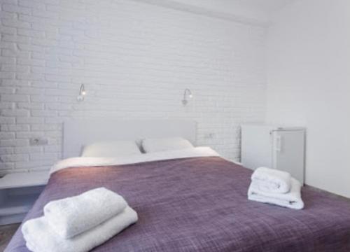 a bedroom with a bed with towels on it at Smart Hotel Rooms near metro 24/7 in Kyiv