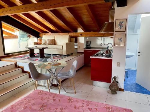 a kitchen and living room with red cabinets and a table at Villa Costantina with heated POOL in Cannobio