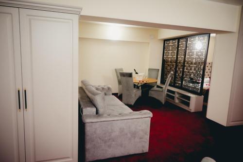 a living room with a chair and a table at Hotel Valahia in Târgovişte