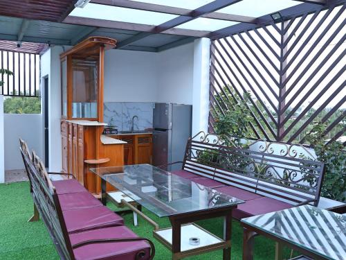 eine Terrasse mit einem Tisch und Stühlen sowie eine Küche in der Unterkunft QV Manor Hotel in Phan Rang