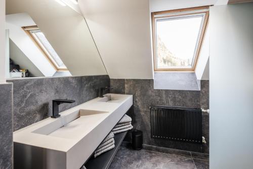 baño con 2 lavabos y ventana en Moxn Chalet Lungau - Authentic Luxury Living, en Ramingstein