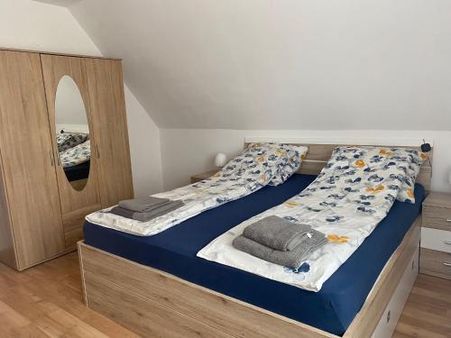 a bedroom with a bed with blue sheets and a mirror at Ferienwohnung Andreea in Vlotho