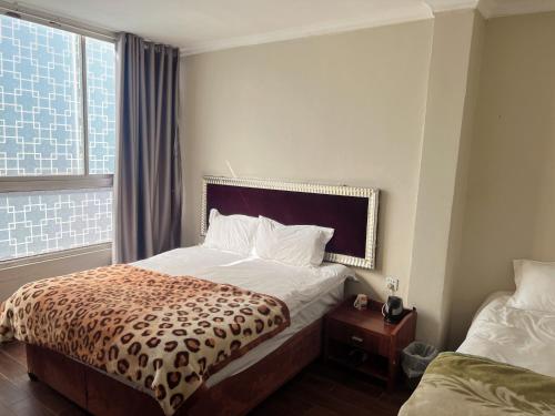 um quarto de hotel com uma cama e uma janela em Shengtang Business Hotel em Joanesburgo