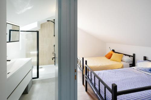 a bedroom with two beds and a bathroom with a shower at Etxe Ttippi in Saint-Jean-de-Luz