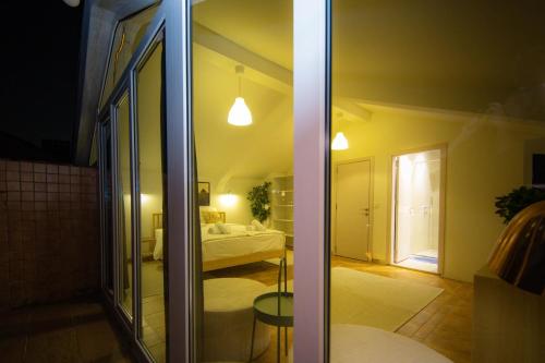 Habitación con dormitorio con cama y puerta de cristal. en Apartments PRN, en Pristina