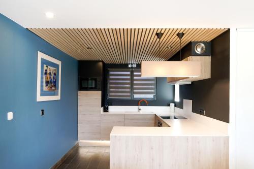 a kitchen with a white counter and a blue wall at Etxe Ttippi in Saint-Jean-de-Luz