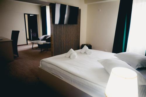 a bedroom with a large white bed with two pillows at Hotel Valahia in Târgovişte