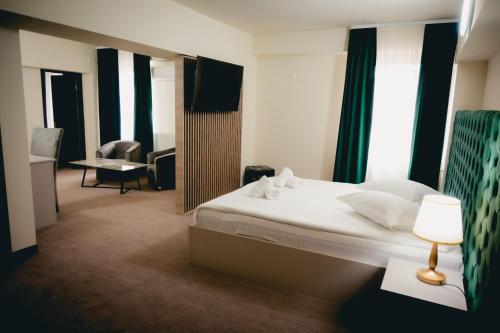 a hotel room with a bed and a table with a lamp at Hotel Valahia in Târgovişte