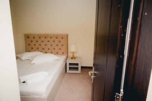 a bedroom with a bed and a table with a lamp at Hotel Valahia in Târgovişte