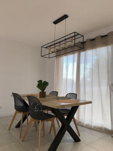 une table à manger avec des chaises et un lustre dans l'établissement Charmante Villa, à Châtellerault