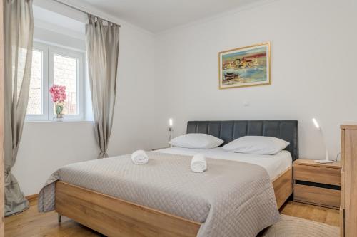 a bedroom with a bed with two towels on it at Da Da in Kaštela