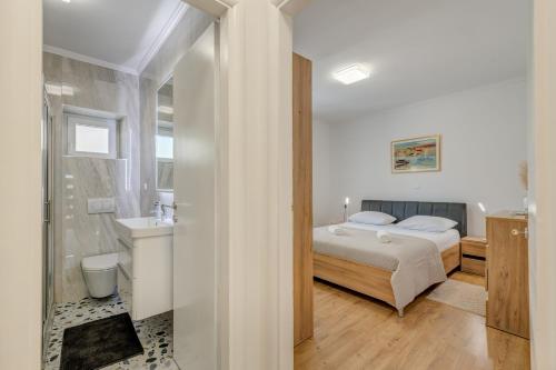 a bedroom with a bed and a bathroom at Da Da in Kaštela
