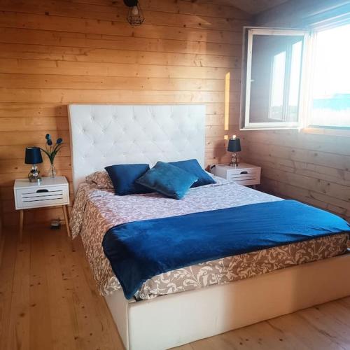 a bedroom with a large bed with blue pillows at Casa da MareRia in Gafanha da Boa Hora