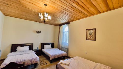 a bedroom with two beds and a wooden ceiling at Christy Hotel in Goris