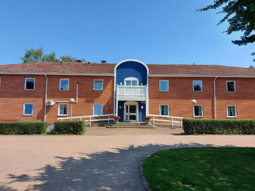 un grand bâtiment en briques rouges avec une porte bleue dans l'établissement Sundsgården hotell & konferens, à Helsingborg