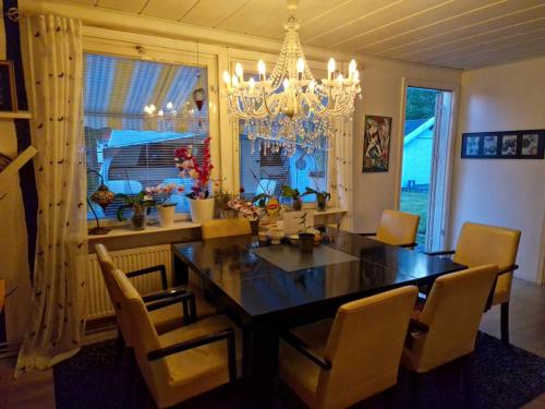 comedor con mesa, sillas y lámpara de araña en Cozy private caravan on our lawn, en Luleå
