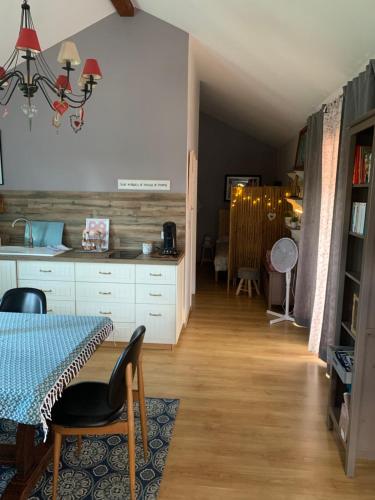 a kitchen with a table and a dining room at My little sweet home in Colombe
