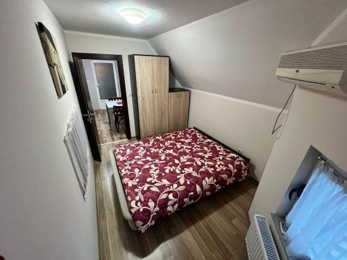 a small room with a bed with a red blanket at Migro Lux Centar in Arilje